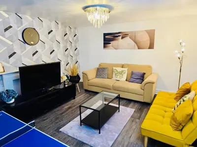 a living room with a yellow couch and a tv at Specious Liverpool Central Apartment in Liverpool