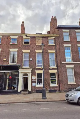 a brick building with a car parked in front of it at Specious Liverpool Central Apartment in Liverpool