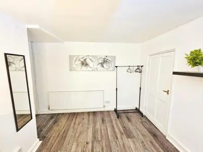 an empty living room with white walls and wood floors at Specious Liverpool Central Apartment in Liverpool