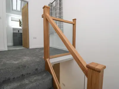 a staircase in a house with wooden railings at Apple Tree Barn in Dalton in Furness
