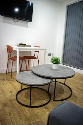 a room with two tables and a table with a potted plant at Sevenstay Apartments Fleet Street in Liverpool