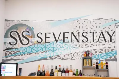 a sign for the sxswagency on a wall with bottles of wine at Sevenstay Apartments Fleet Street in Liverpool