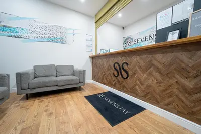 a waiting room with a chair and a reception counter at Sevenstay Apartments Fleet Street in Liverpool