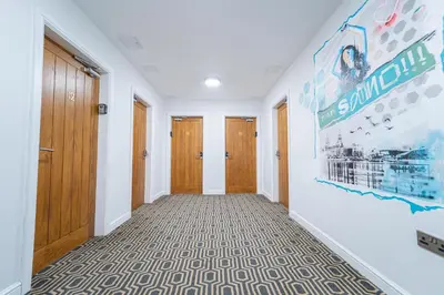 a hallway with wooden doors and a mural on the wall at Sevenstay Apartments Fleet Street in Liverpool