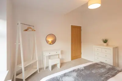 a bedroom with a bed and a dresser and a mirror at Host & Stay - Bay View House in Grange Over Sands