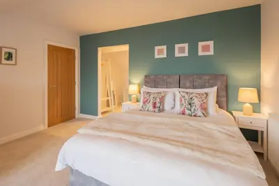 a bedroom with a large bed and a blue wall at Host & Stay - Bay View House in Grange Over Sands