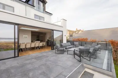 a patio with chairs and a table on a balcony at Host & Stay - Bay View House in Grange Over Sands