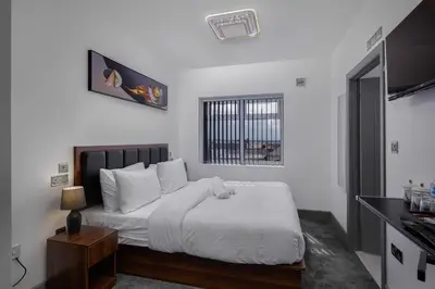 a bedroom with a white bed with a dog laying on it at Empire Inn in Blackpool