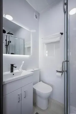 a white bathroom with a toilet and a sink at Empire Inn in Blackpool