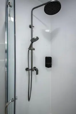 a shower with a glass door with a shower head at Empire Inn in Blackpool