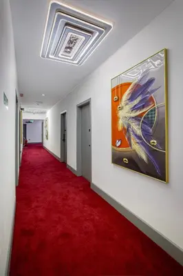 a hallway with a red carpet and a painting on the wall at Empire Inn in Blackpool