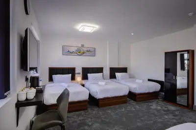 a bedroom with two beds and a desk and a chair at Empire Inn in Blackpool