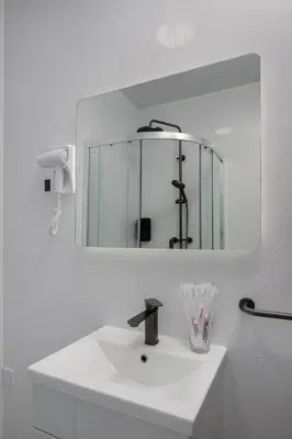 a white bathroom sink with a mirror above it at Empire Inn in Blackpool