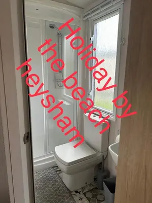 a bathroom with a toilet and a sign that says the word bathroom at Holiday escapes by the bay in Heysham