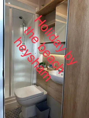 a bathroom with a white toilet and a sink at Holiday escapes by the bay in Heysham