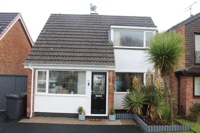 a white house with a black door at Beautiful home near beach in Formby