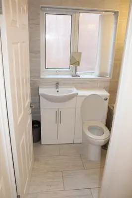 a bathroom with a toilet and a sink and a window at Beautiful home near beach in Formby