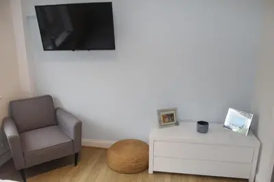a living room with a chair and a tv at Beautiful home near beach in Formby