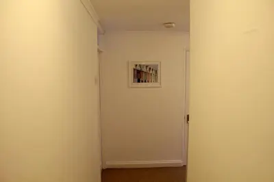 a hallway with a white wall with a picture on it at Beautiful home near beach in Formby
