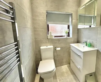 a bathroom with a toilet and a sink and a window at Modernised 3-bed home in Bamber Bridge, Preston in Bamber Bridge