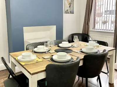 a dining room with a table with chairs and a table at Modernised 3-bed home in Bamber Bridge, Preston in Bamber Bridge