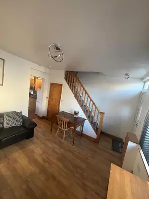 a living room with a staircase and a table at Morecambe Bay Cottage in Morecambe