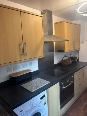 a kitchen with a black counter top with a dishwasher at Morecambe Bay Cottage in Morecambe