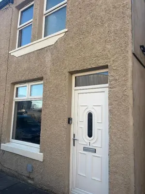 a white door on the side of a building at Morecambe Bay Cottage in Morecambe