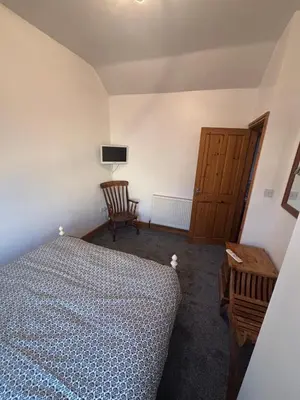 a bedroom with a bed and a chair and a table at Morecambe Bay Cottage in Morecambe