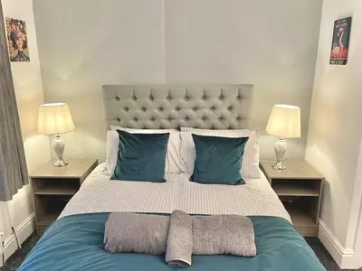 a bedroom with a large bed with blue pillows at Ideal 4-bed stay-away-home sleeps 6 in Preston in Preston