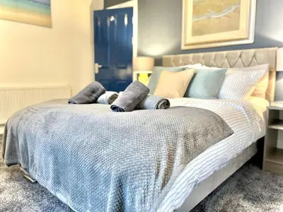 a bedroom with a bed with a blue and white comforter at Ideal 4-bed stay-away-home sleeps 6 in Preston in Preston
