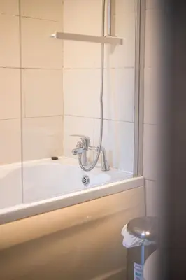 a bath tub with a shower in a bathroom at Silvester Residence in Liverpool