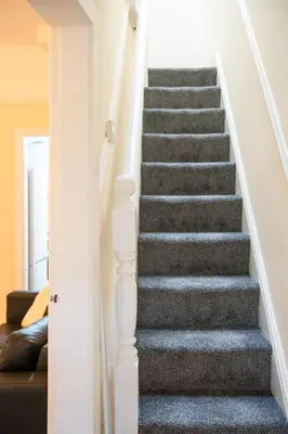 a staircase in a home with grey carpet at Silvester Residence in Liverpool