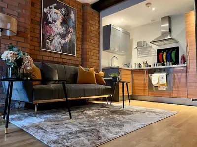 a living room with a couch and a kitchen at Beautiful City Centre 2 Bedroomed Apartment in Liverpool