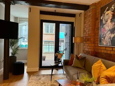 a living room with a couch and a brick wall at Beautiful City Centre 2 Bedroomed Apartment in Liverpool