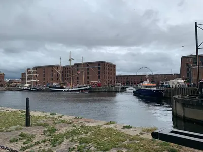 a river with boats docked in a city with buildings at Beautiful City Centre 2 Bedroomed Apartment in Liverpool