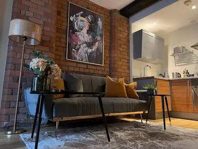 a living room with a couch and a brick wall at Beautiful City Centre 2 Bedroomed Apartment in Liverpool