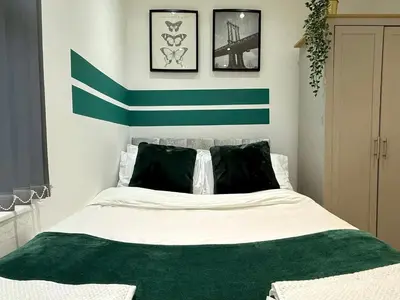 a bedroom with a green and white striped wall at Liverpool Serviced Apartment - Mallow in Liverpool
