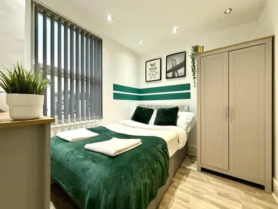 a bedroom with a bed with a green blanket at Liverpool Serviced Apartment - Mallow in Liverpool