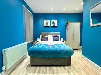 a blue bedroom with a large bed in it at Liverpool Serviced Apartment - Mallow in Liverpool