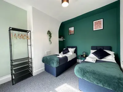 two beds in a room with green walls at Liverpool Serviced Apartment - Phillimore in Liverpool