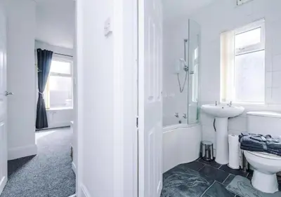 a white bathroom with a sink and a toilet at Liverpool Serviced Apartment - Phillimore in Liverpool