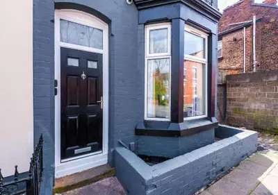 a blue house with a black door and a window at Liverpool Serviced Apartment - Phillimore in Liverpool