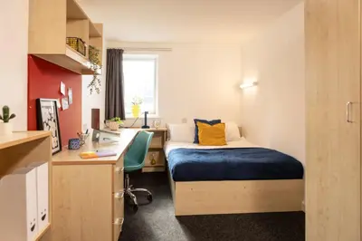 a small room with a bed and a desk and a sink at Albert Court in Liverpool in Liverpool