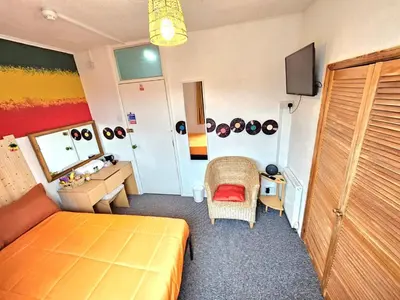 a bedroom with a bed and a desk and a mirror at Hotel Claytou in Blackpool