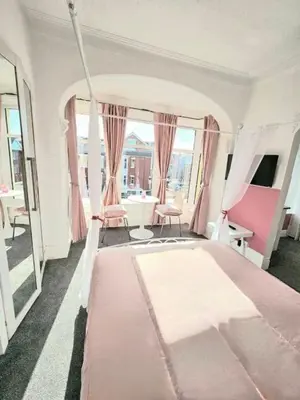 a bedroom with a large pink bed in a room at Hotel Claytou in Blackpool