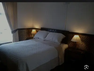 a bedroom with a large bed with two lamps at Number 10 in Blackpool