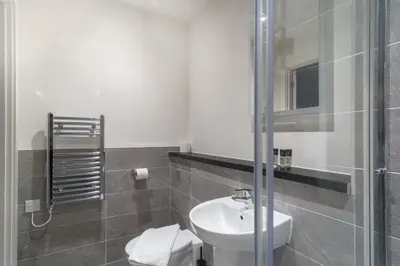 a bathroom with a sink and a glass shower at Fabulous Studio in Central Liverpool in Liverpool