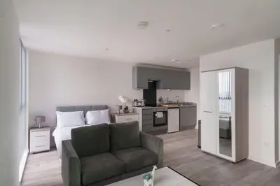 a living room with a bed and a couch and a kitchen at Fabulous Studio in Central Liverpool in Liverpool