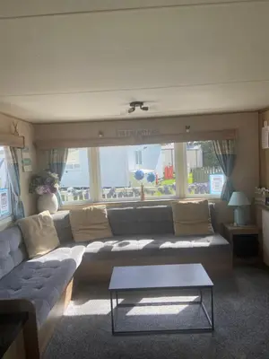 a living room with a large couch and a table at Haven Lakeland Caravan Hire in the Lake District in Flookburgh